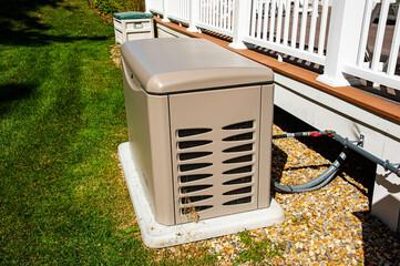 Whole home standby generator on an elevated pad with gas and electrical connections at a residence
