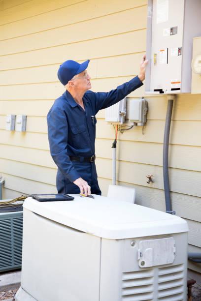 Licensed technician connecting a whole home automatic transfer switch to a standby generator at a residence